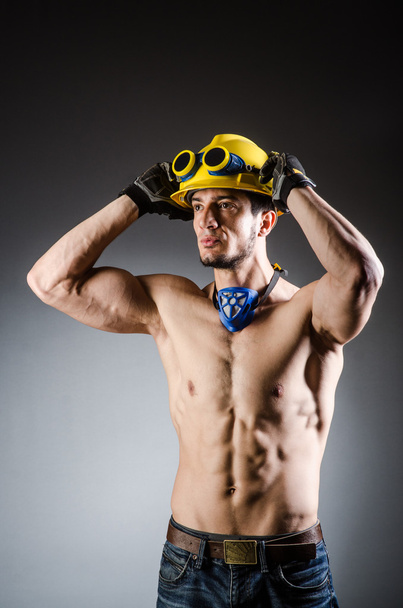 Разорванный мускулистый строитель с инструментами - Фото, изображение