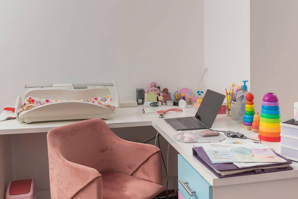 bureau d'un bureau pédiatrique, avec ordinateur portable, jouets et matériel pédiatrique - Photo, image