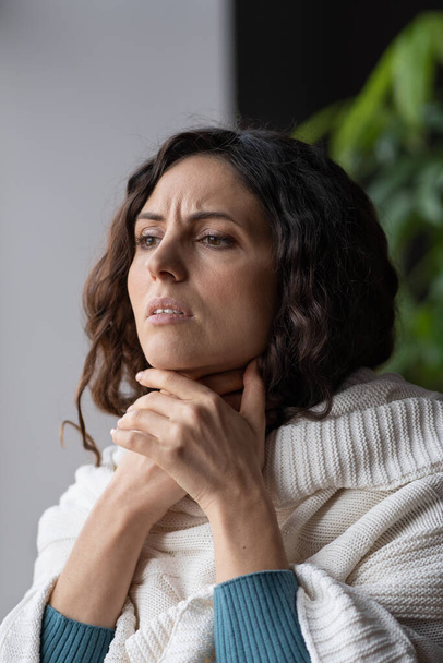 Lymphadenopathie. Kranke Frau berührt geschwollene Lymphdrüsen, Frau mit Erkältungssymptomen zu Hause - Foto, Bild