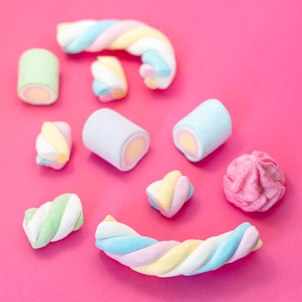 Marshmallows on pink background. Assortment of candies and sweets in pink background. Marshmallow in pastel colors with copy space - Fotó, kép