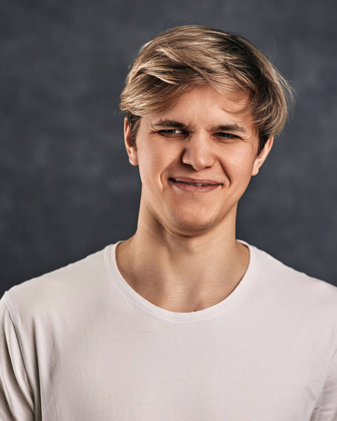 young man frowning on gray background. Human emotions - Fotografie, Obrázek