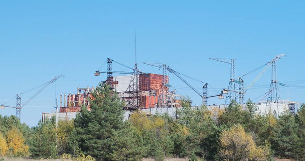 Άποψη του ημιτελούς αντιδραστήρα στο Τσερνομπίλ. Γερανοί πάνω από ένα πυρηνικό εργοστάσιο. Εγκαταλελειμμένο βιομηχανικό κτίριο, πανόραμα. Μεγάλο πλάνο, καλοκαίρι. - Φωτογραφία, εικόνα