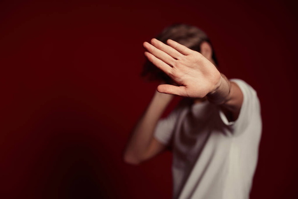 young man in white t-shirt showing stop gesture at camera - Photo, image