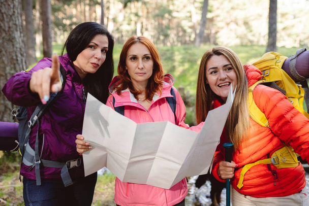 grupo de mulheres maduras com um mapa na natureza mochileiros trekking, conceito de vida saudável - Foto, Imagem