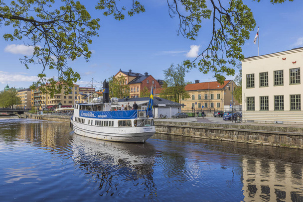 Beautiful view of white tourist excursion boat on cityscape background. Sweden. Uppsala. 05.14.2022. - Foto, afbeelding