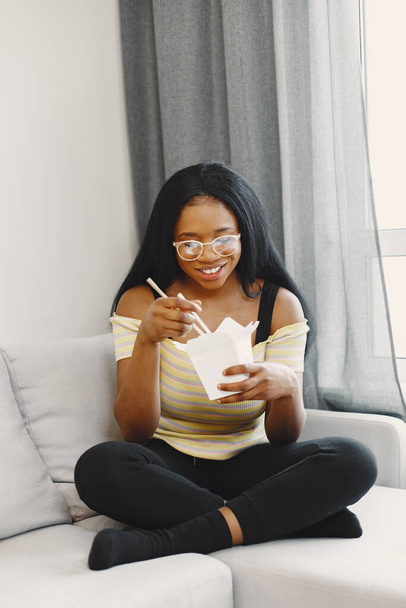 Beautiful young african american woman eating noodles - Foto, imagen