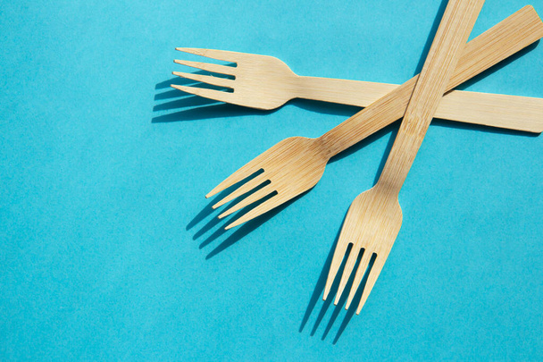 Wooden bamboo cutlery on bright blue background - Photo, Image