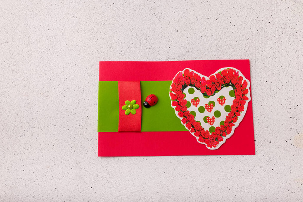 Izmail, Ucraina. 14 febbraio 2022. Cartolina di San Valentino con cuore rosso, fiori e coccinella su sfondo bianco - Foto, immagini