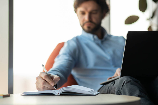 Blisko człowieka za pomocą laptopa i pisania w notebooku - Zdjęcie, obraz
