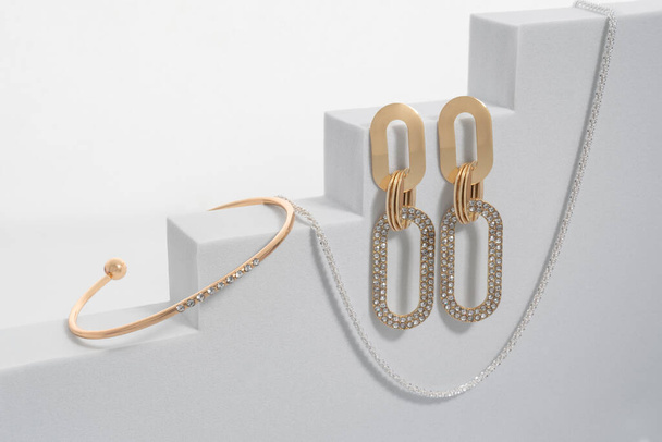 Geometric modern bracelet and earrings pair on white geometric background - Foto, afbeelding
