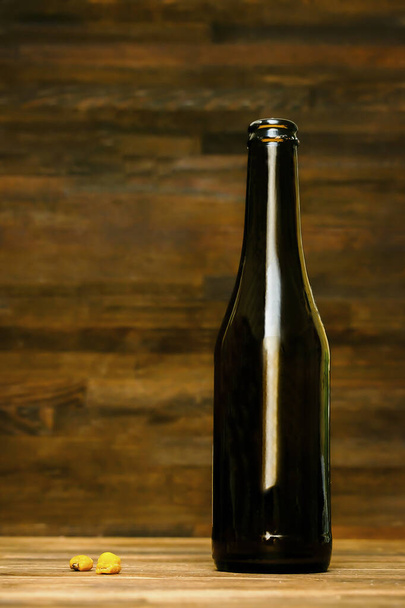 Glass brown bottle of beer,ale and corn, nuts snacks on wooden table, background close up. Alcohol cocktail, bar drink, booze party concept.mockup, template, copy space. - Foto, Imagen