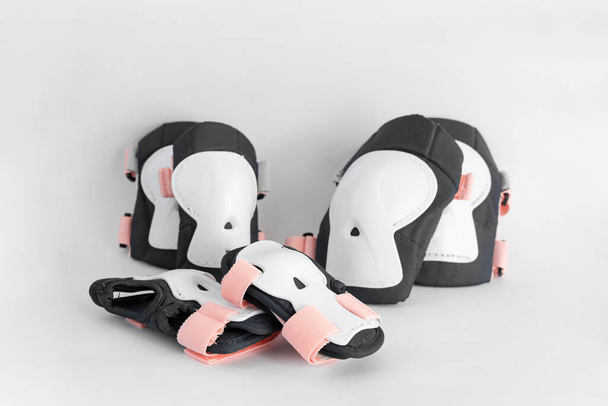 Top view of roller skates protective gear set - knee, elbow and wrist pads in pink colors. White grey background side view - Photo, image