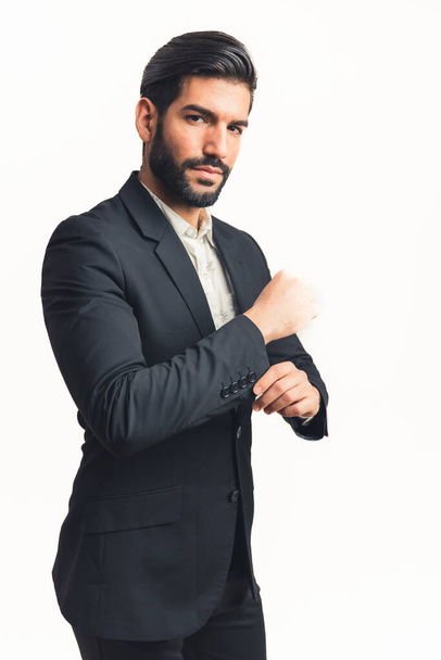 young man wearing a suit fastering a button while looking at the camera, isolated white background, vertical - Фото, зображення