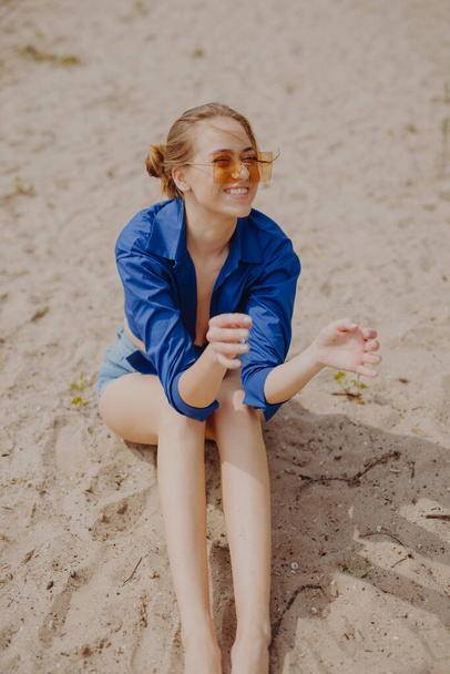 Happy funny young woman smiling sitting on the beach - Fotoğraf, Görsel