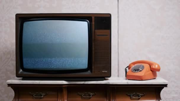 Oude televisie zonder signaal en statisch effect op het scherm met oude telefoon op vintage set - Video