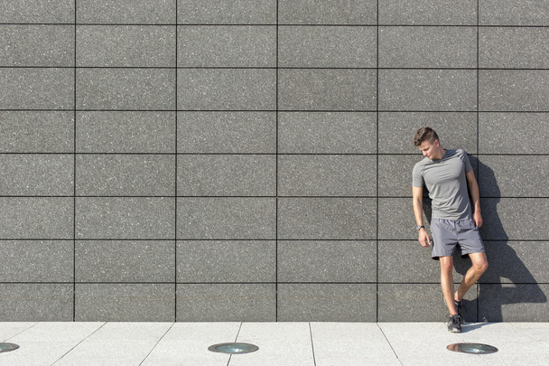 sporty man leaning on wall - Zdjęcie, obraz