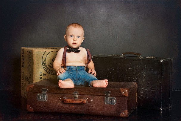 スーツケースの上に座ってジーンズの子 - 写真・画像