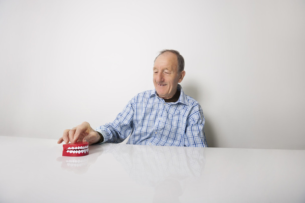 Man with dentures at table - Fotoğraf, Görsel