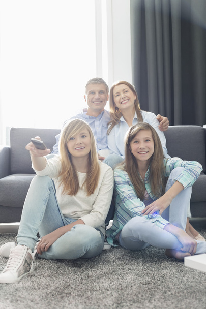 Family of four watching TV together - Foto, Bild