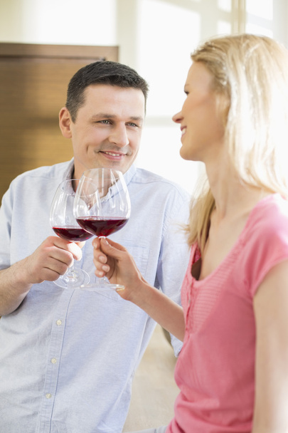 couple toasting red wine glasses - Фото, изображение