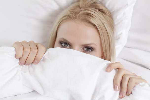 Woman covering face with bed sheet - Photo, Image