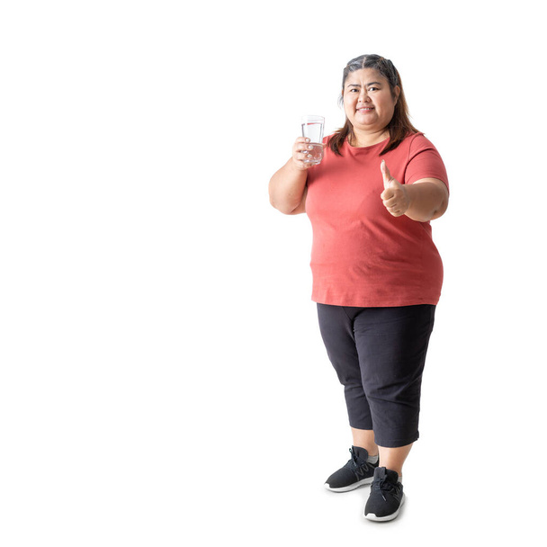 Fat woman asian happy smiling holding a glass of water and thumbs up, isolated white on background - Foto, Imagen