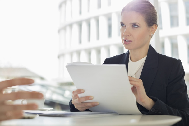 Businesswoman discussing paperwork with colleague - Photo, image