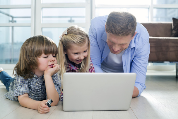 Father with children using laptop - 写真・画像