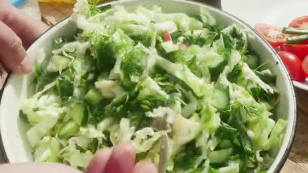 ένα χέρι με πιρούνι αναμιγνύει λαχανικά σε ανοιξιάτικη σαλάτα. - Πλάνα, βίντεο