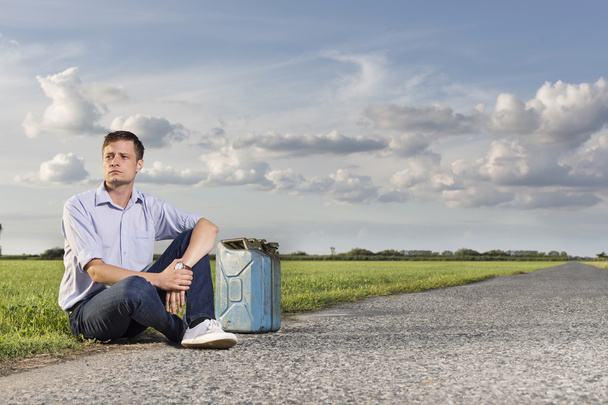 Uomo seduto sulla strada di campagna
 - Foto, immagini