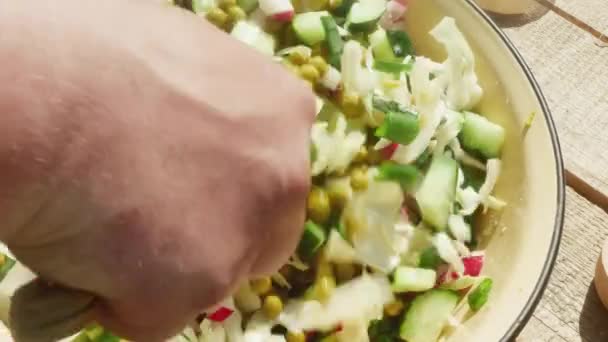  το χέρι ανακατεύει ανοιξιάτικη σαλάτα με μπιζέλια σε κονσέρβα με μαχαίρι. - Πλάνα, βίντεο