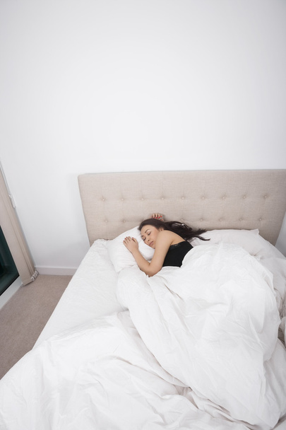Vrouw die in bed slaapt - Foto, afbeelding