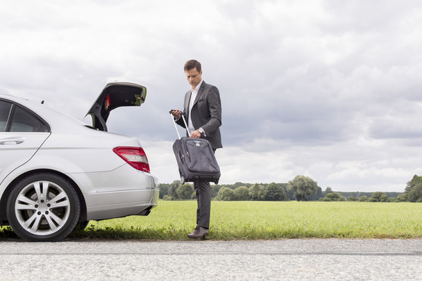 Businessman taking suitcase from car - Photo, Image