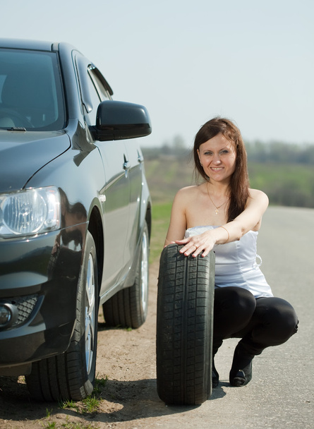 Woman changing car wheel - Foto, afbeelding