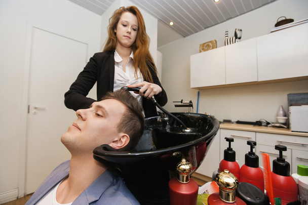 hairstylist washing customer's hair - Zdjęcie, obraz