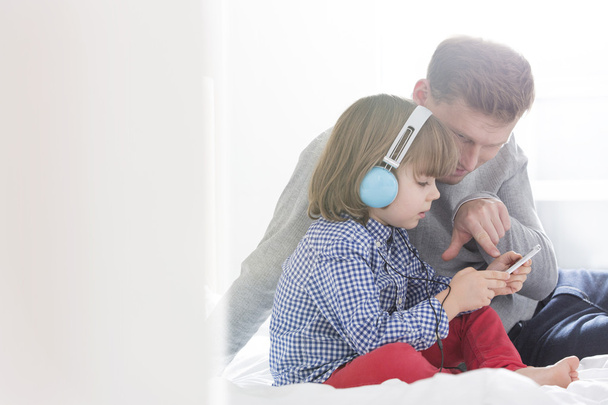Père avec garçon écoutant de la musique
 - Photo, image