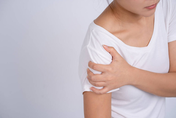 Γυναίκα που υποφέρει από πόνο στον ώμο, επώδυνη στους μύες του χεριού. Βραχίονες μύες που απομονώνονται σε λευκό φόντο. - Φωτογραφία, εικόνα