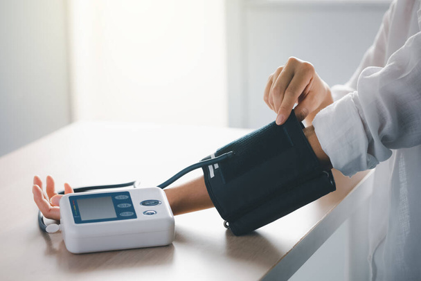 vérnyomás- és pulzusmérés vérnyomásmérő géppel, egészségügyi ellátással és orvosi koncepcióval - Fotó, kép