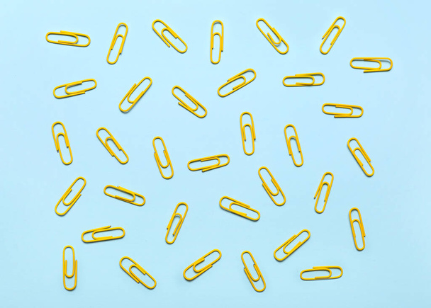 Yellow paper clips on blue background - Фото, зображення