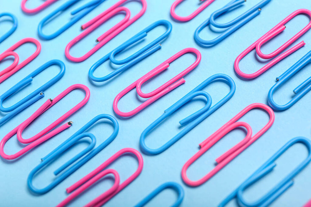 Roze en blauw papier clips op kleur achtergrond, close-up - Foto, afbeelding
