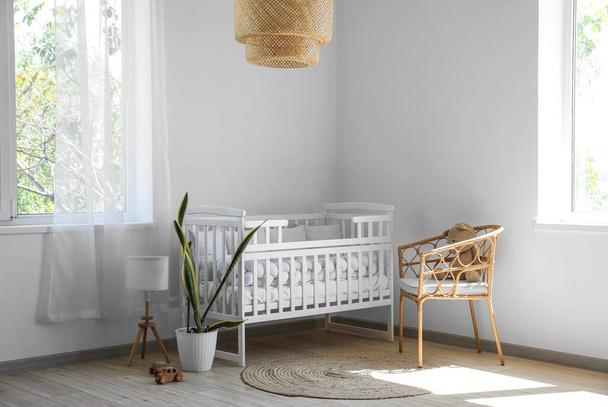 Baby crib, armchair and toys in light nursery - Photo, Image