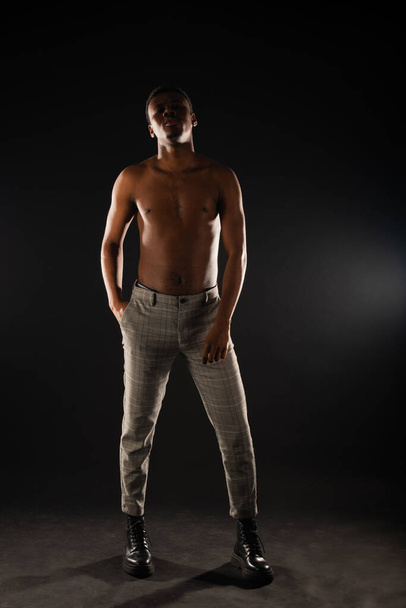 African black male is having a great posture of posing on black background - Foto, Imagem