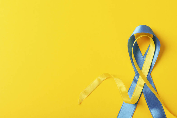 Υποστήριξη της Ουκρανίας έννοια, μπλε και κίτρινες κορδέλες ευαισθητοποίησης σε κίτρινο φόντο - Φωτογραφία, εικόνα
