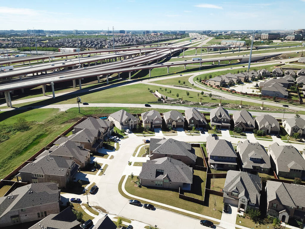 Top pohled obytné čtvrti v blízkosti rušné dálnice s hromadnou křižovatkou v blízkosti Dallasu, Texas, Amerika. Velký nový vývoj dvou patrových domů s dřevěným plotem a malým dvorkem - Fotografie, Obrázek