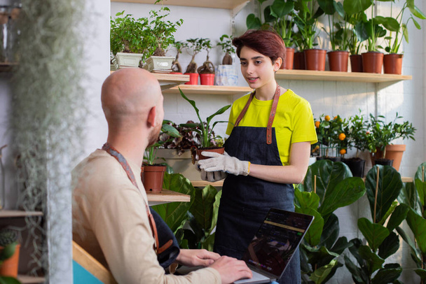 In the floral store concept of small business entrepreneur the owner of the shop have a conversation with the florist lady - Foto, Imagen