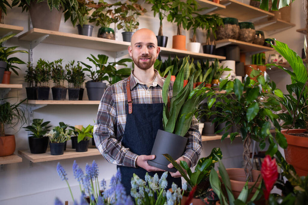 Portret van mannelijke bloemist met armen gekruist zijn bloemenwinkel - Foto, afbeelding