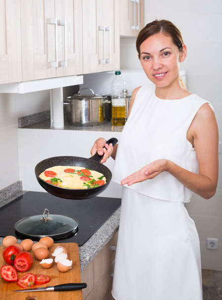 woman preparing omelet in pan - Foto, Bild