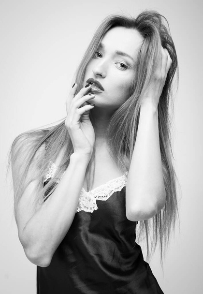 Sensual girl with long hair in a black silk nightdress. Fashion vogue style portrait. Beautiful young woman - Foto, Imagem