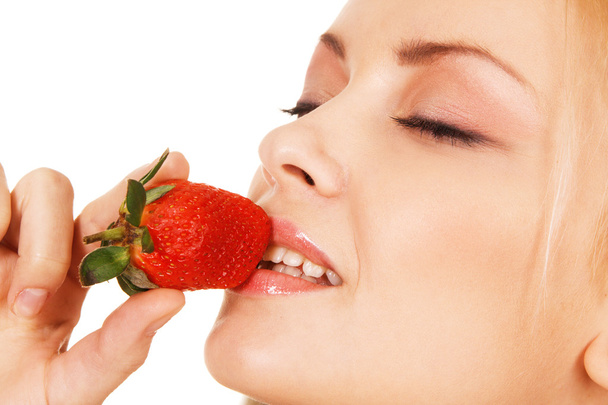 Beautiful girl tasting a strawberry - Foto, Bild