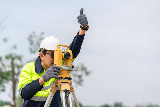 Surveyor Civil Engenheiro polegar-se com equipamentos no canteiro de obras. - Foto, Imagem